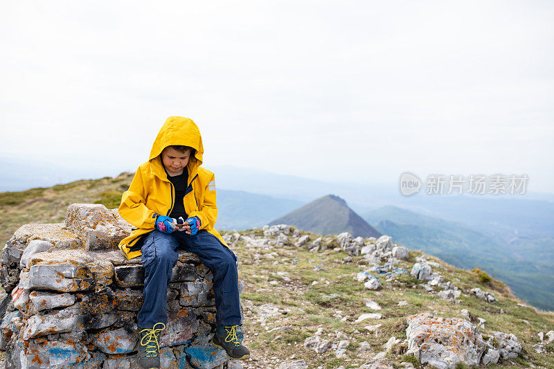 一个男孩在山顶上吃零食