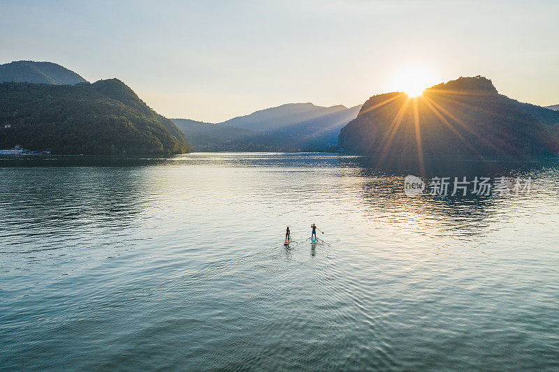 从空中俯瞰日落时分湖面上的两个划桨者