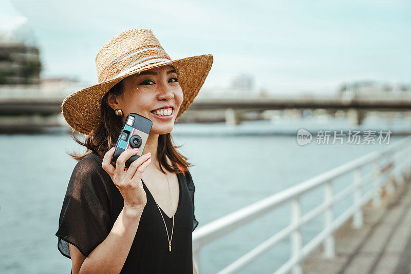 年轻女子用一次性相机拍照