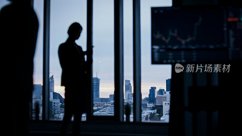 摩天楼窗户上的商业人士剪影。股票市场交易分析