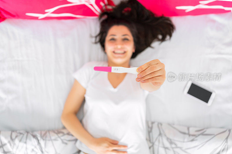 怀孕测试呈阳性的兴奋女性。庆祝孕检阳性结果。是的，我怀孕了
