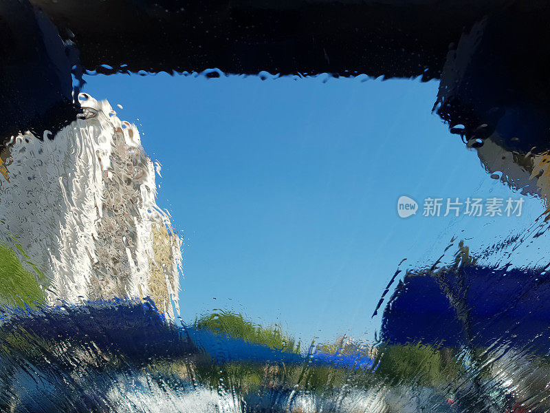 洗车抽象飞溅水滴波模式挡风玻璃从内部清洗车窗清洁蓝天扭曲建筑隧道雨棚车库复制空间特写