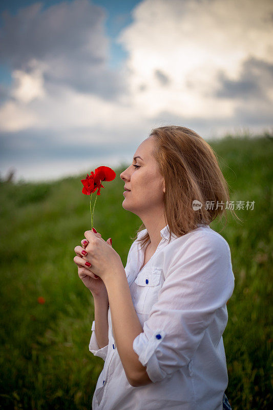 女人拿着罂粟，普通的罂粟，红色的花