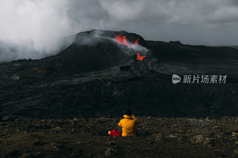 在冰岛的法格达尔斯火山喷发时，游客们感到敬畏