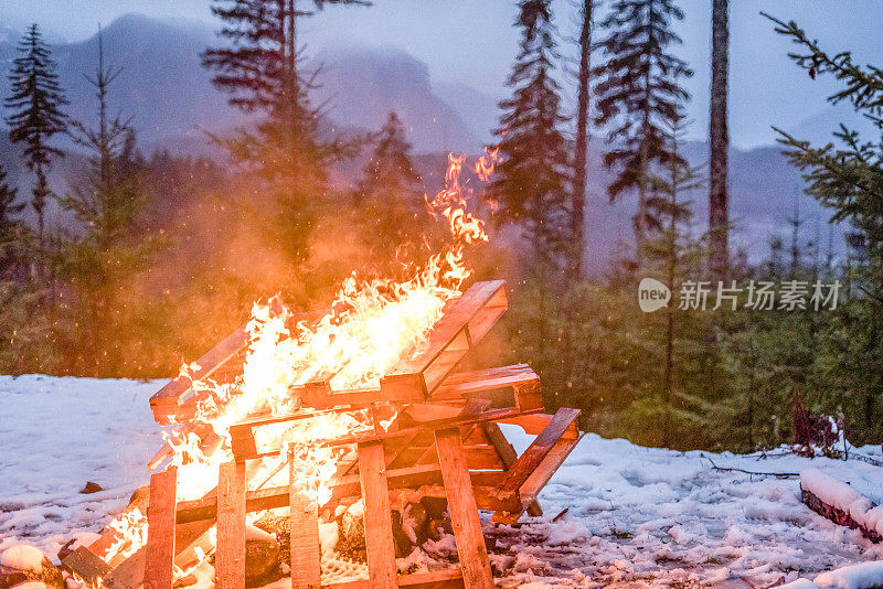 白雪覆盖的森林地面上的篝火风景