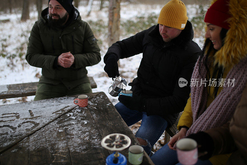 朋友们在雪堆上喝着热饮的照片