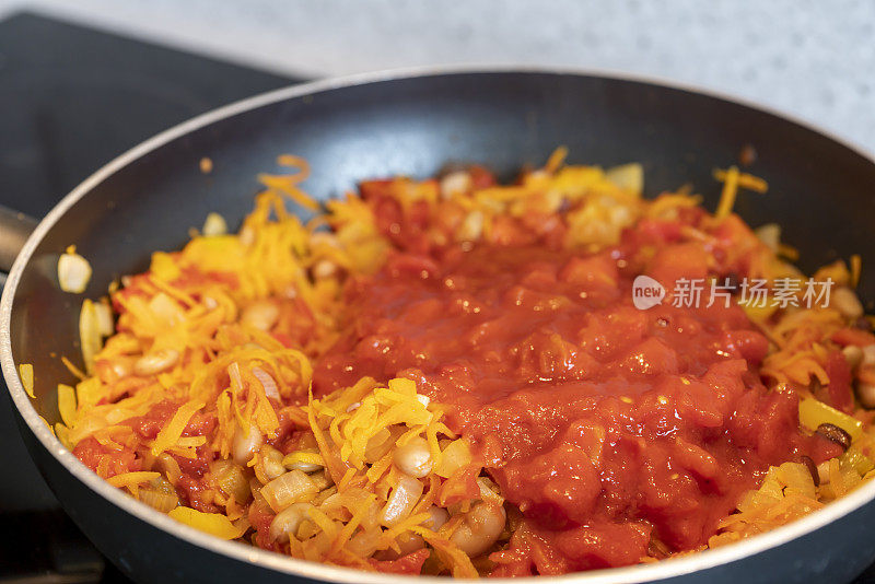 在现代厨房的电磁炉上烹饪素食玉米卷饼。