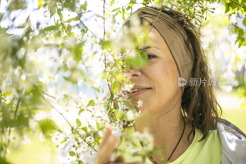 带着盛开的樱桃树的黑发女人