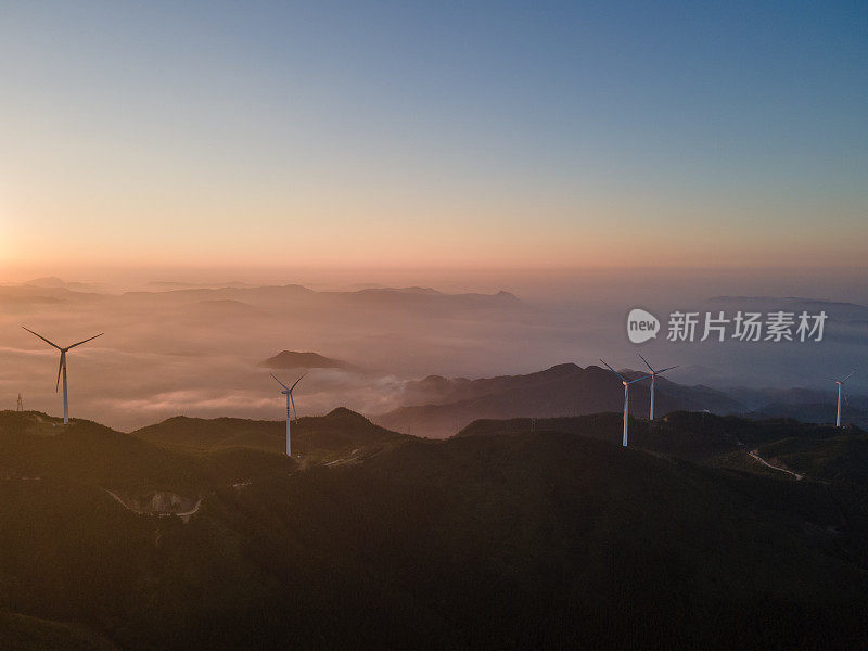 清晨的太阳和云海，山上的风力涡轮机