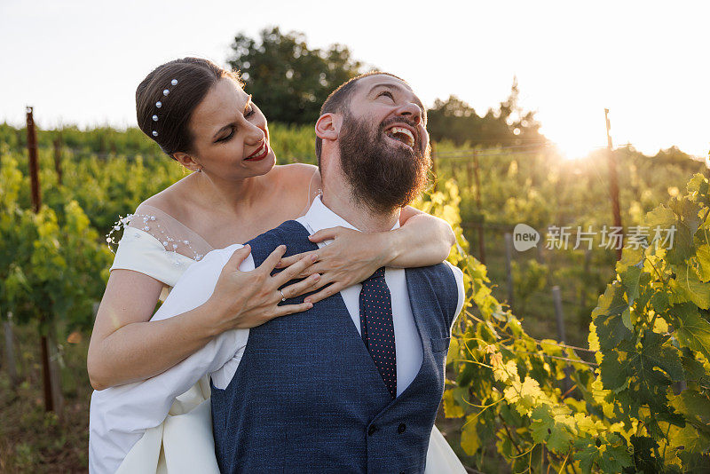 年轻的新婚夫妇在葡萄园玩得很开心