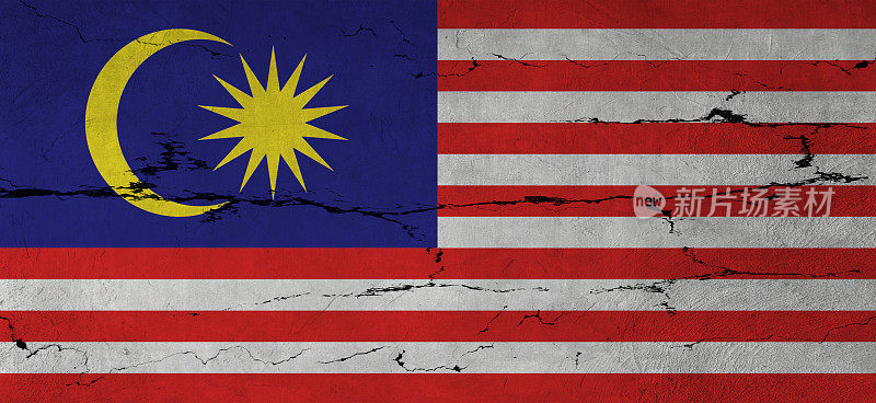 开裂的墙上挂着马来西亚国旗