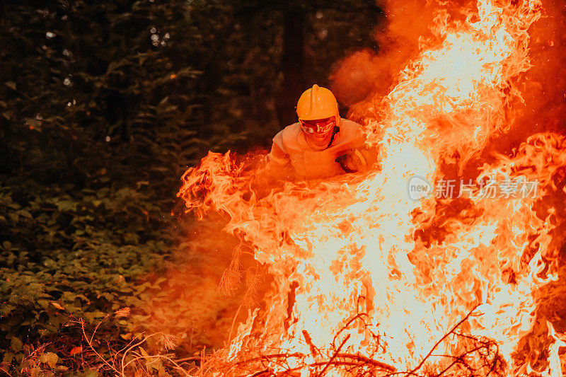 消防英雄在行动中危险地跳过大火火焰进行救援和拯救