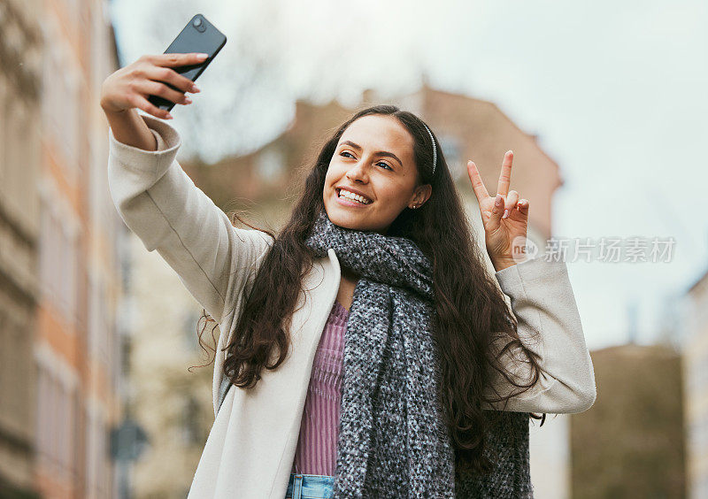 旅行，和平或快乐的女人在一个轻松的假期或周末在伦敦市的社交媒体上自拍。微笑，手势或兴奋的女孩游客独自自豪地拍摄有趣的照片