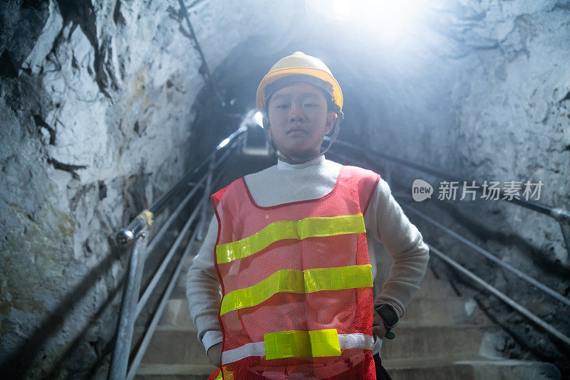 年轻的矿工站在通往矿井隧道的台阶上