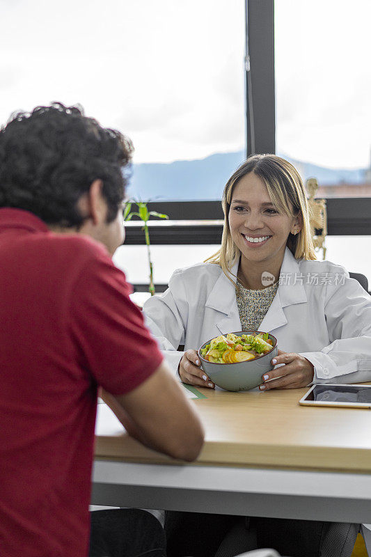 营养学家为病人提供蔬菜沙拉健康饮食咨询。健康饮食计划及适当营养的概念。