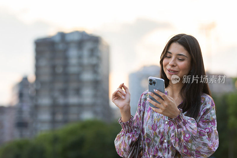 衣着讲究的年轻女子正在用便携式设备查看邮件。