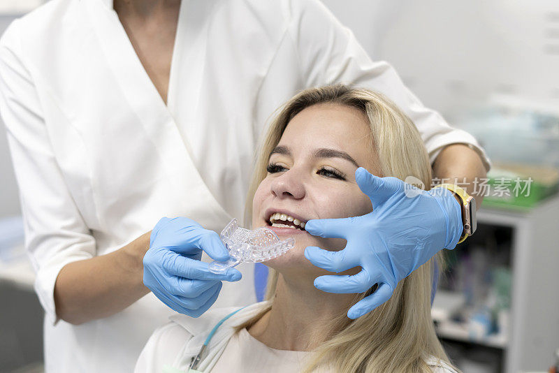 牙科医生在塑料托盘上制作牙模，正畸治疗概念