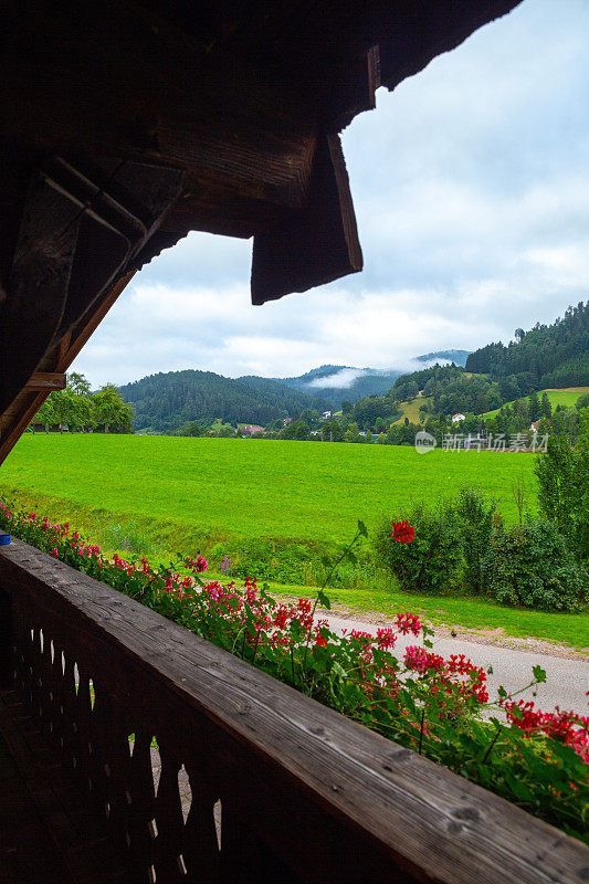 从一个传统的德国阳台看出去Fachwerkhäuser山和花在黑森林，度假