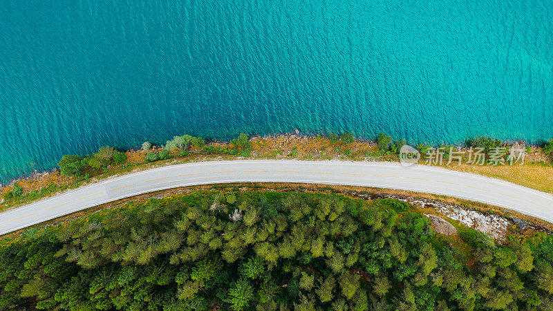 公路在森林和水晶蓝湖之间的夏日风景鸟瞰图