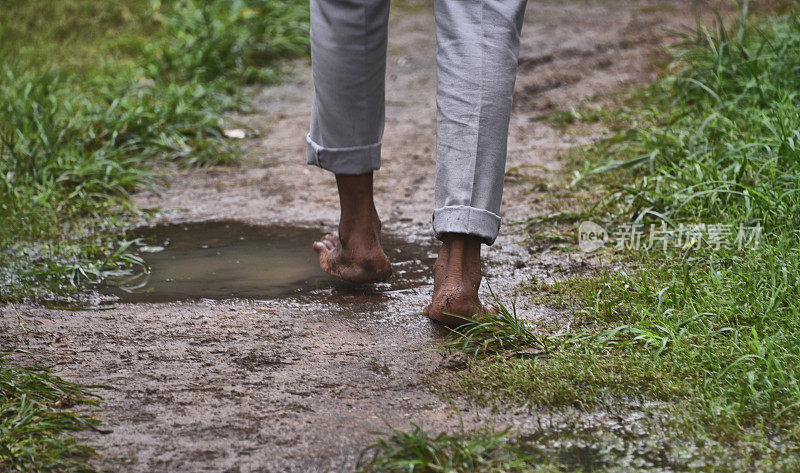 一个人赤脚在雨中走