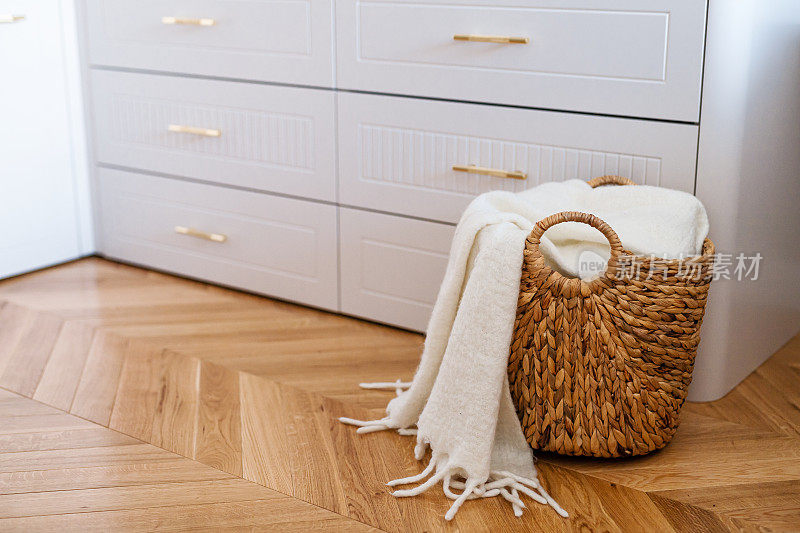 衣柜抽屉和编织柳条篮洗衣与白色毯子，关闭。
