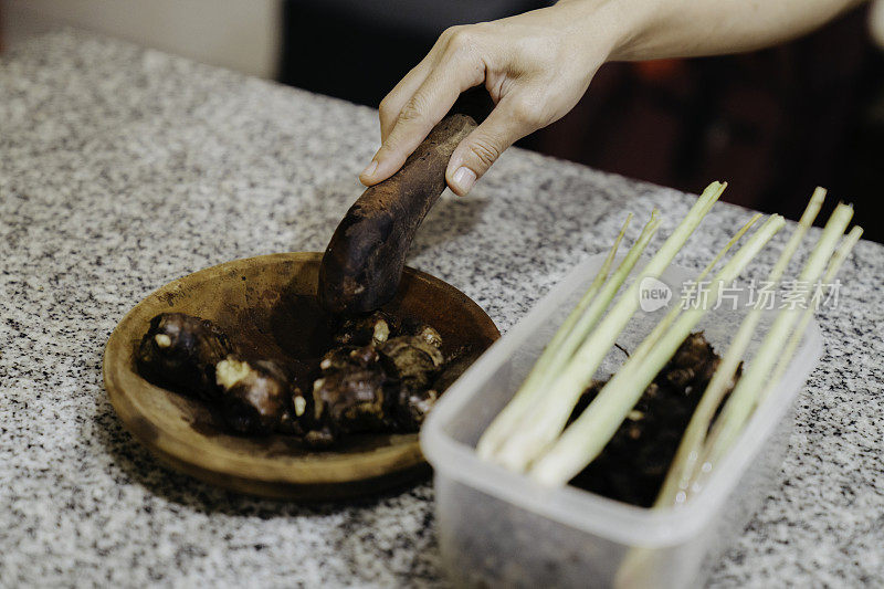 特写妇女在厨房剥大蒜(用新鲜原料制作健康食品)