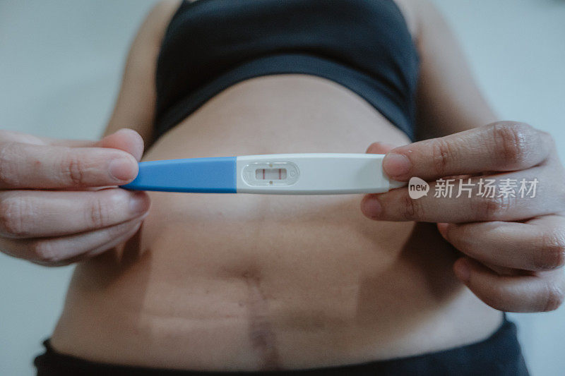一名亚洲妇女正在验孕。