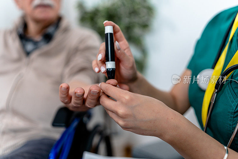 坐在轮椅上的老人由志愿者检查血糖水平