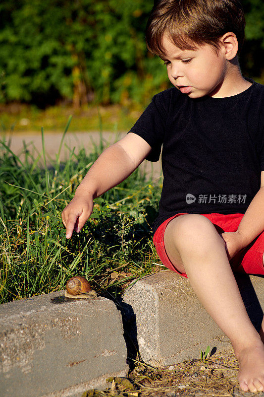 一个孩子摸着一只蜗牛