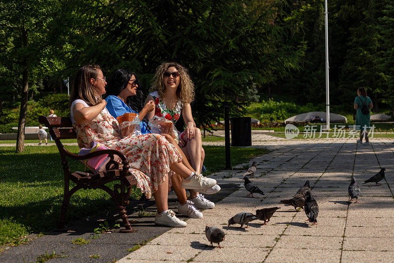 女人们坐在长凳上聊天。