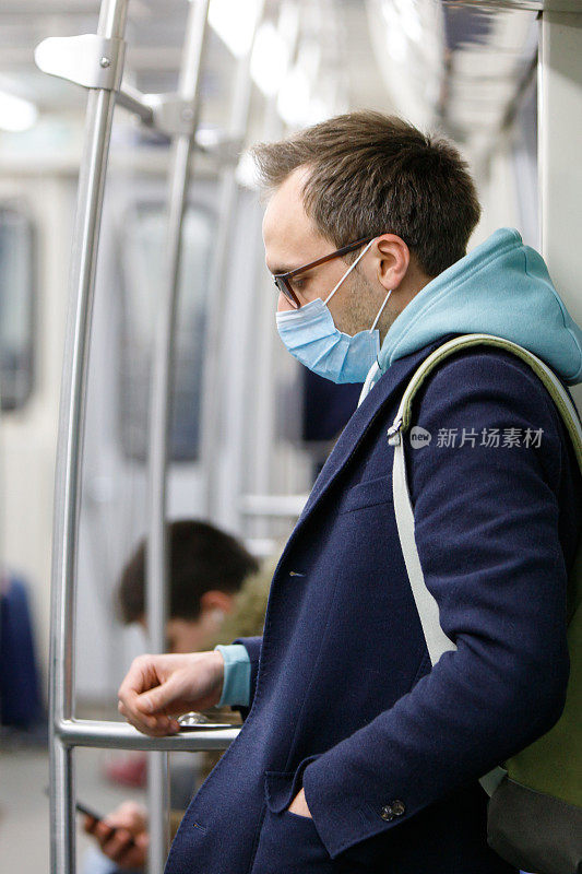 在公共交通工具上戴防护面具的男子