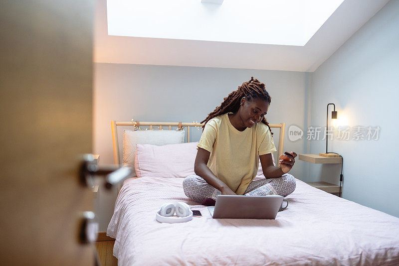 年轻的非裔美国女人在床上网购