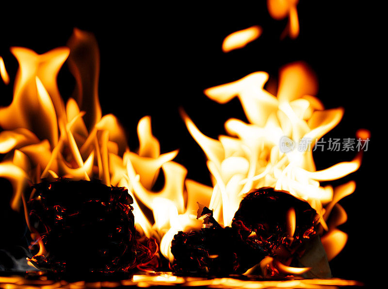 火焰火焰火焰燃烧在黑色背景孤立。在纸上燃烧着抽象的纹理。火在纸上燃烧成灰烬并产生火焰。照片真实的高分辨率模糊失焦