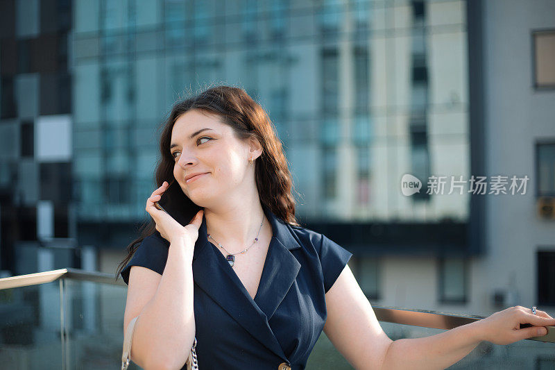 一个面带微笑的女人一边打电话一边看向别处