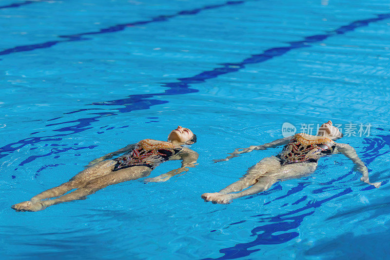 优雅的女子花样游泳二重唱在他们专门的训练课程，掌握复杂的动作与流动性和准确性
