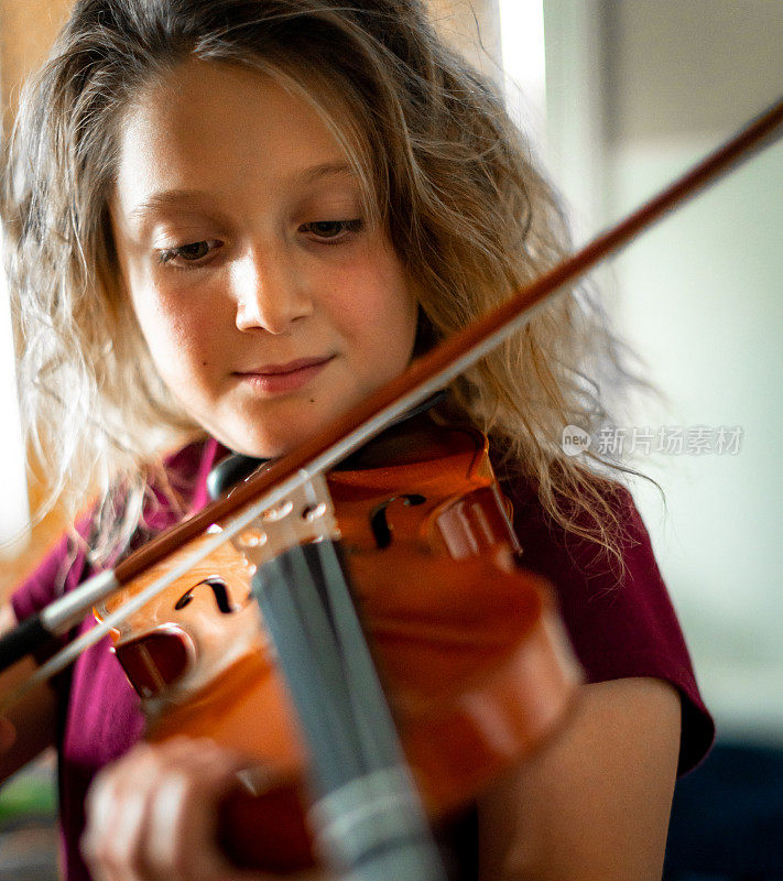 严肃的小学音乐家，女孩练习拉小提琴