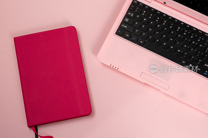 粉色笔记本，粉色背景，女性化的工作场所
