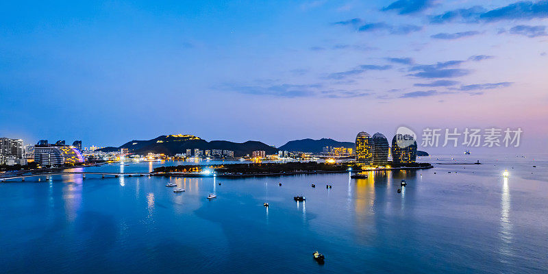 中国海南三亚湾凤凰岛和天际线的航拍夜景