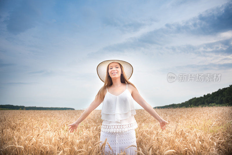 一位女士正在麦田里散步