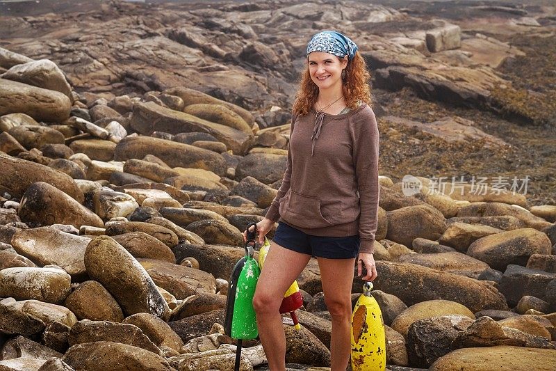 沿海缅因州，岩石海滩，头巾女人携带龙虾浮标