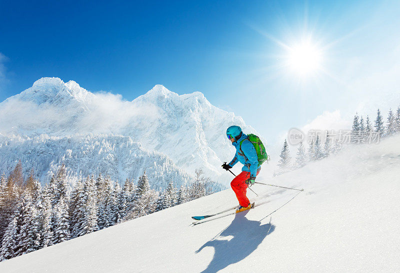 免费的滑雪者在新鲜的粉状雪中向山下跑