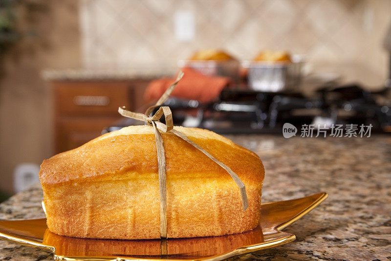 新鲜烘焙的柠檬磅蛋糕放在花岗岩厨房柜台上。