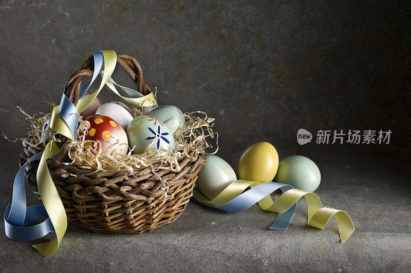 带丝带的柳条篮子里的复活节彩蛋。彩色图像