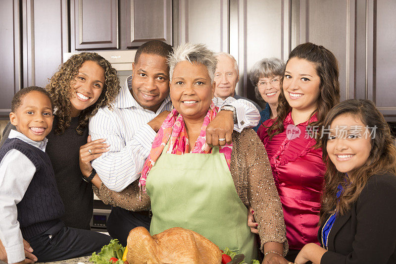 感恩节:多民族家庭、朋友聚在厨房准备大餐。