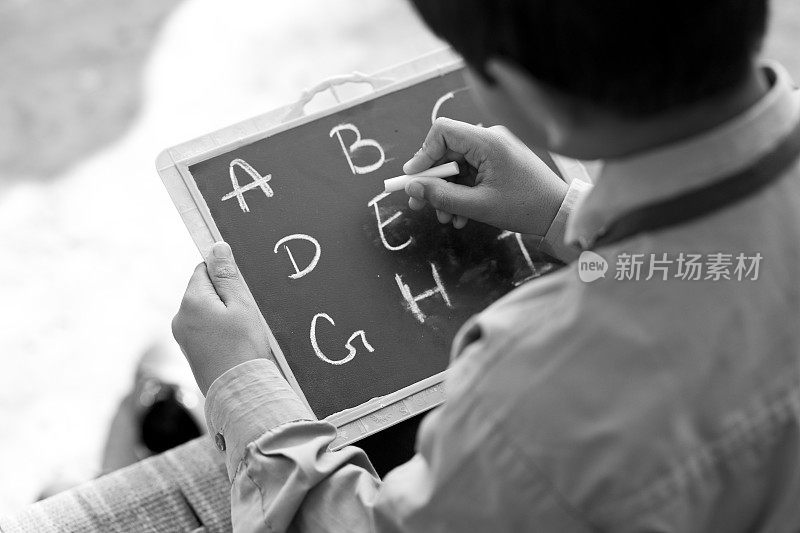 男孩在学校的石板上写字