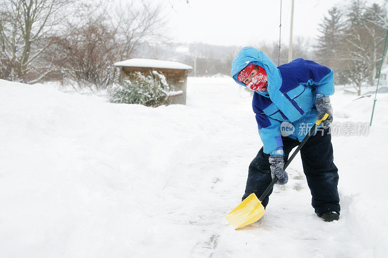 孩子在缤纷的冬天穿铲雪