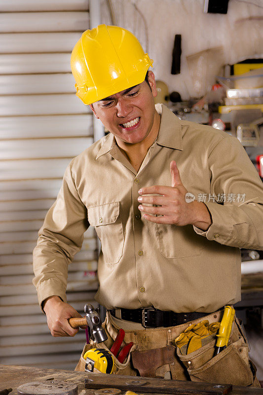 建筑安全:工人在工作中弄伤拇指。