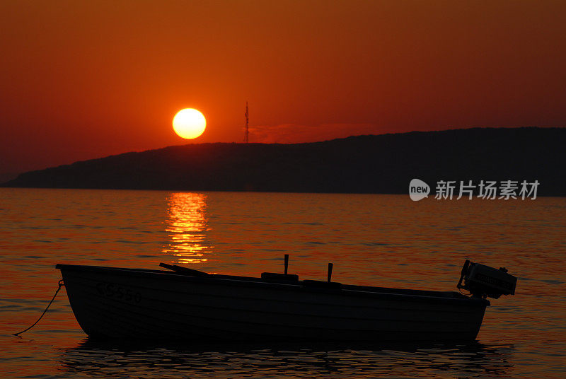 美丽的日落在山上与船在前面