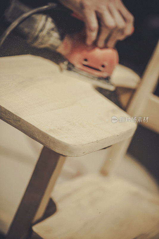 打磨木椅表面以进行修复。DIY。