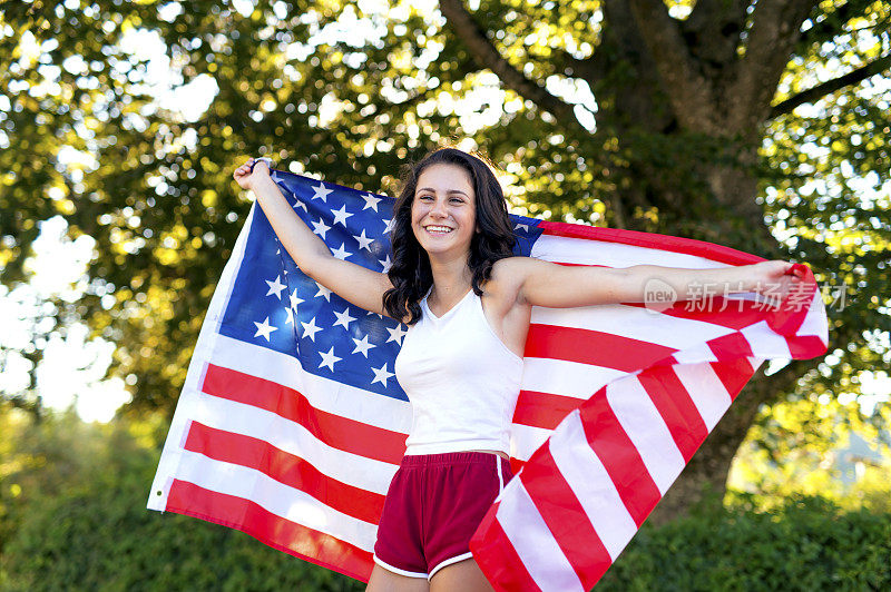 可爱的少女背后举着一面美国国旗